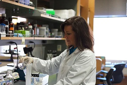 A researcher in a white lab coat works in the lab.